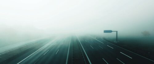 road disappearing into fog stock photo